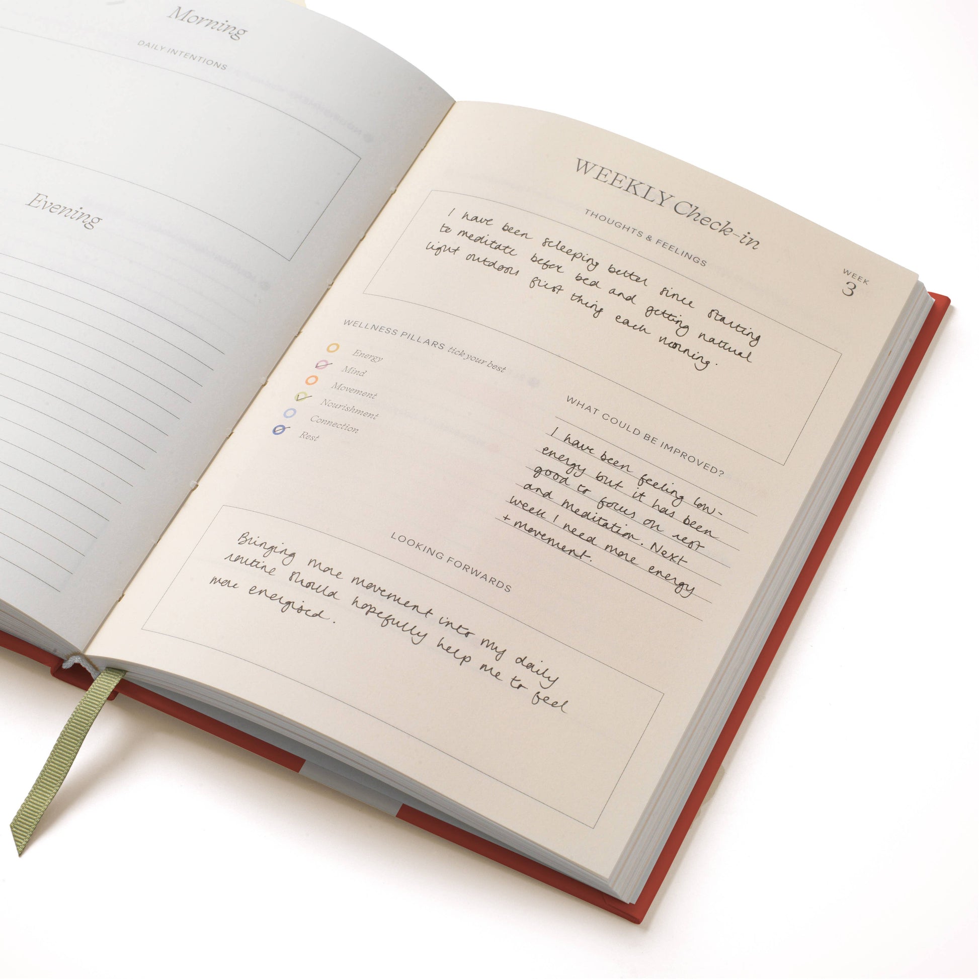 Open guided wellness journal with lined pages by Floral Ikat, showing handwriting and a page marker.