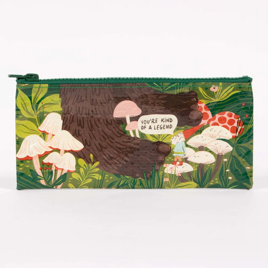 Pencil case by Blue Q with a bigfoot and gnome illustration, mushrooms, and a green zipper.