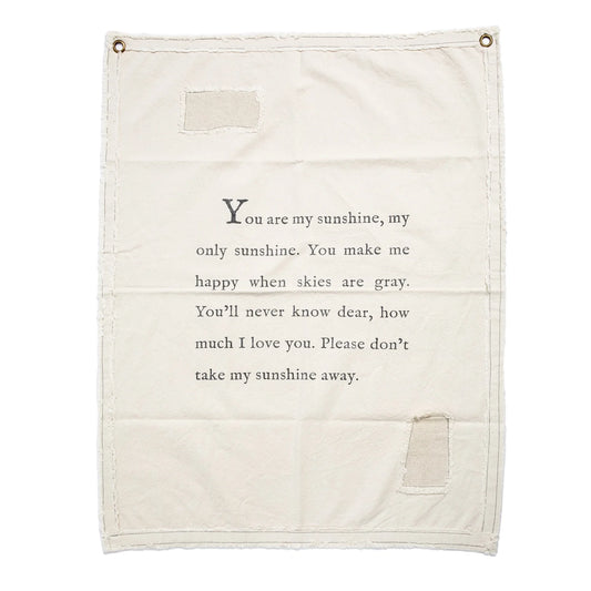 Cream canvas wall hanging by P Graham Dunn, featuring a sentimental "You are my sunshine" quote and rustic patch details.
