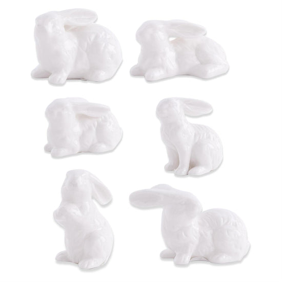 Assorted white porcelain bunnies by Creative Brands in a variety of poses.