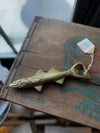 Gold fish bottle opener with twine, sitting on a distressed wooden box.