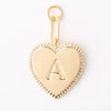 Gold letter "A" heart charm by Amelia, featuring small clear gems around the perimeter and a gold clasp.