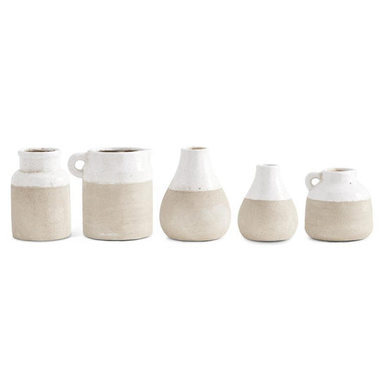 Ceramic two-tone glazed pots with beige bottoms and white tops, from an eye-level perspective.

