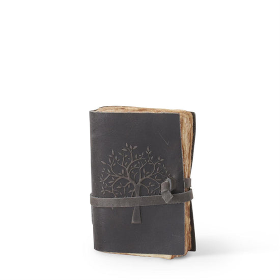 Black leather journal with tree design and strap closure on a white background