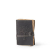 Black leather journal with tree design and strap closure on a white background