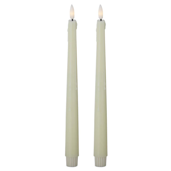 Two lit candles on a white background