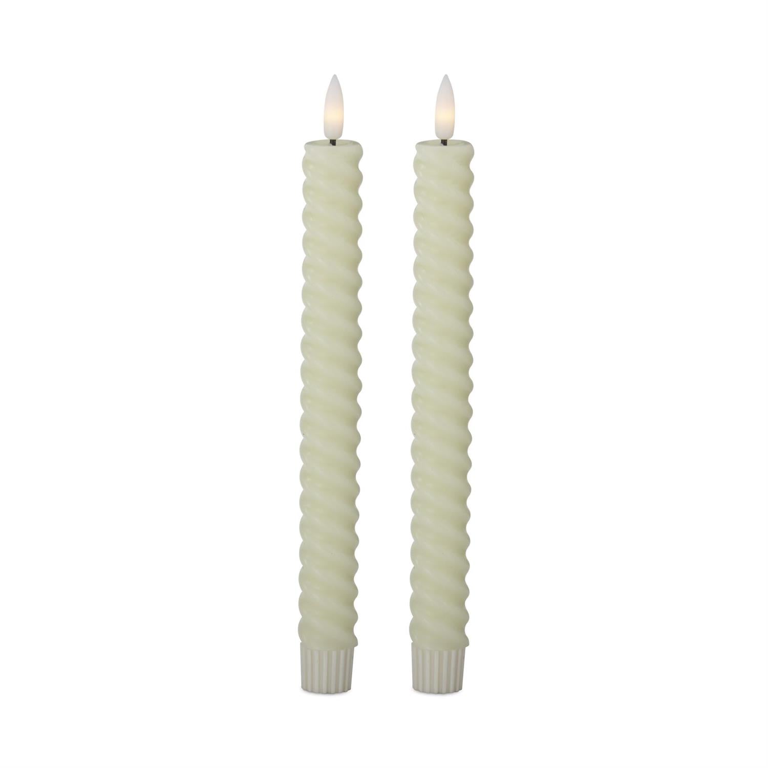 Two twisted candles with white wicks on a white background