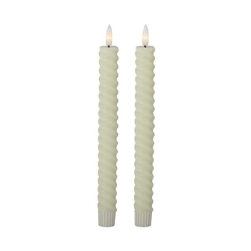 Two twisted candles with white wicks on a white background