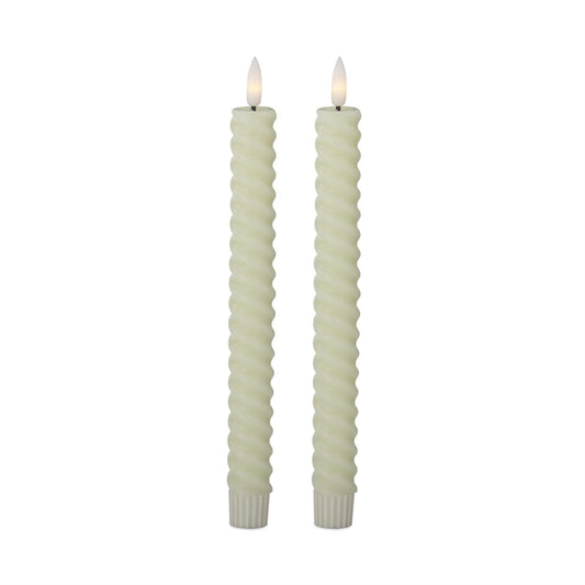 Two twisted candles with white wicks on a white background