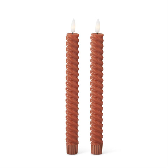 Two twisted candles on a white background