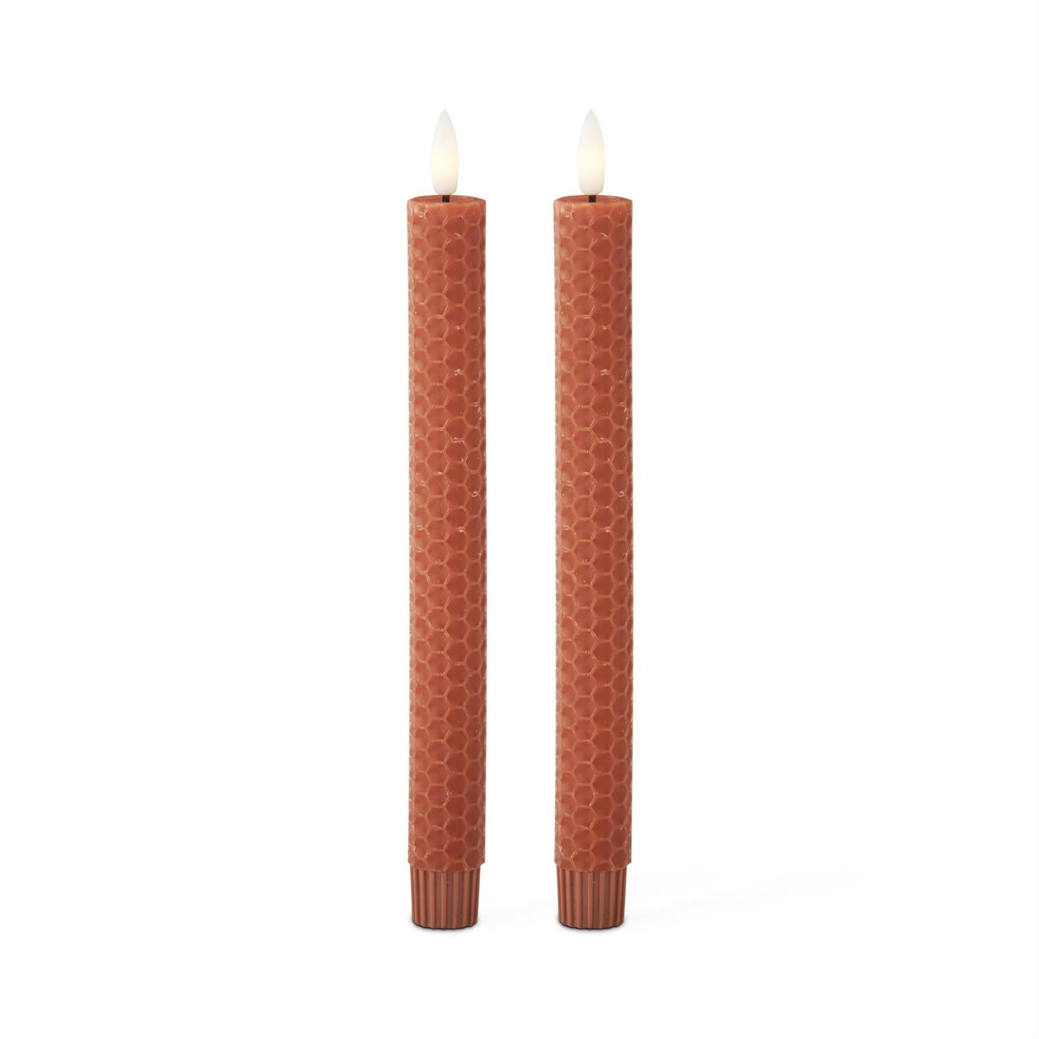 Two brown textured candles on a white background