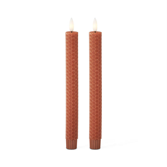 Two brown textured candles on a white background