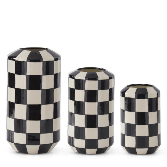 Three black and white checkered vases of different sizes on a white background