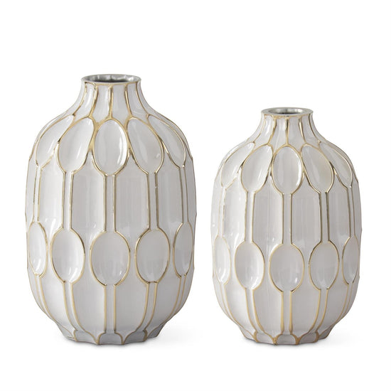White and gold embossed vases by Studio A Home with oval geometric pattern on a glossy surface.
