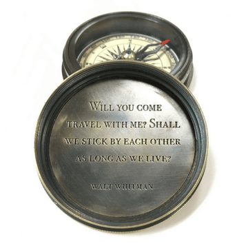 Brass compass with engraved quote by Walt Whitman, featuring a leather pouch.