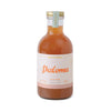 Paloma cocktail mixer from Here's How, in a clear glass bottle with a gold lid and label.
