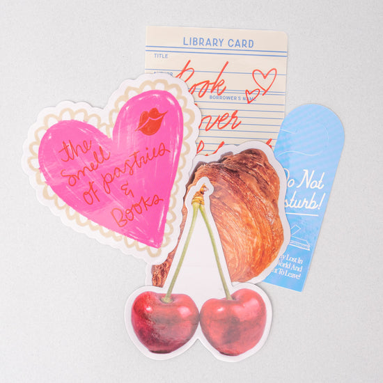 Assorted stationery stickers with library card, heart, cherries, and croissant designs.