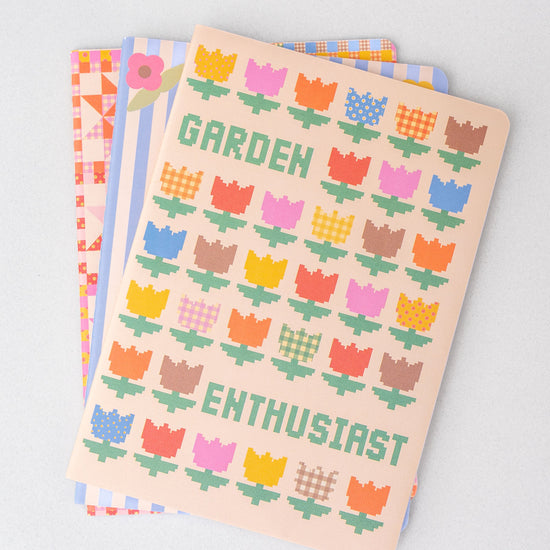 Set of three stationery notebooks with patterned covers from stationery, featuring geometric and floral designs.