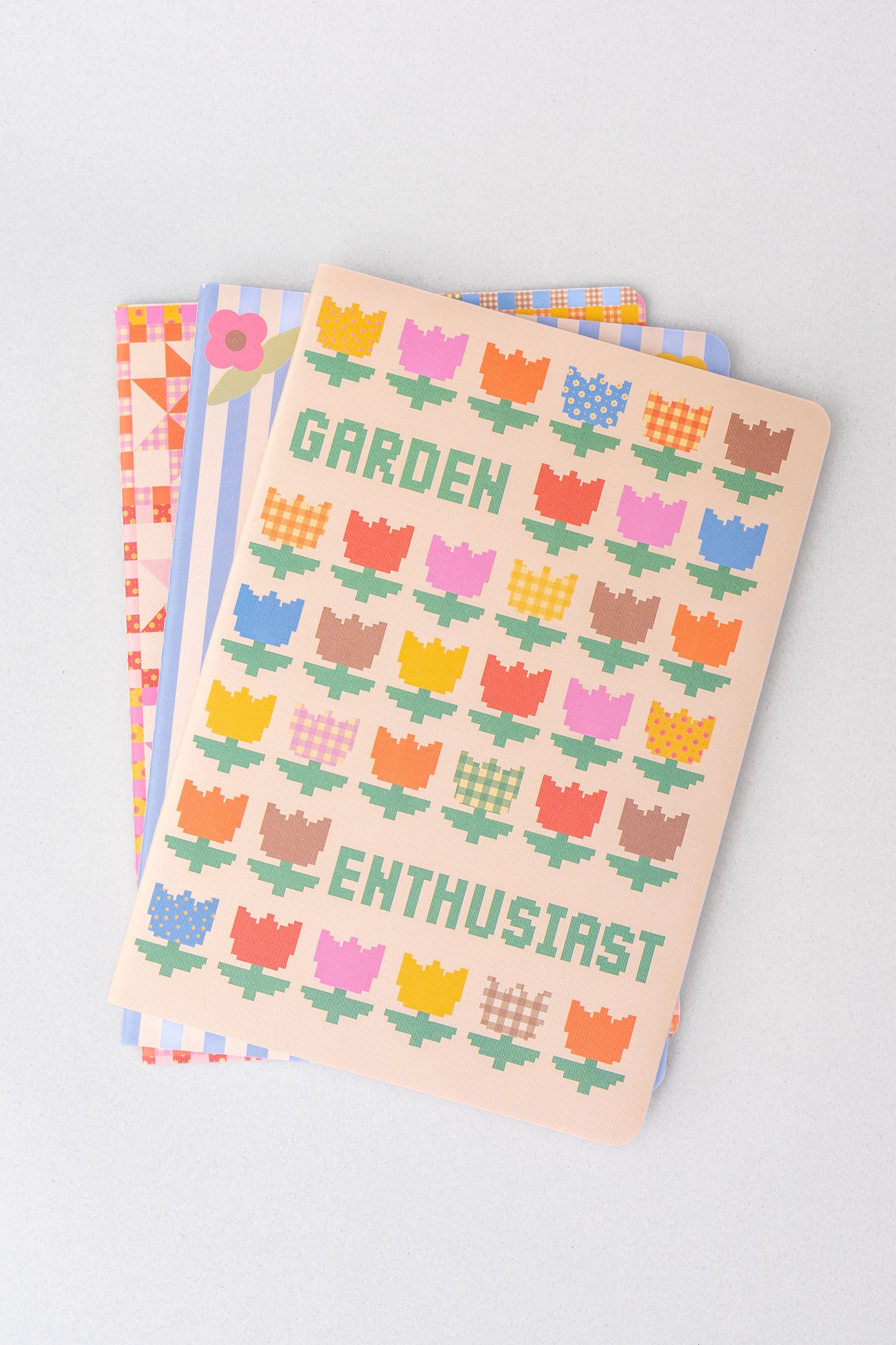 Set of three stationery notebooks with patterned covers from stationery, featuring geometric and floral designs.