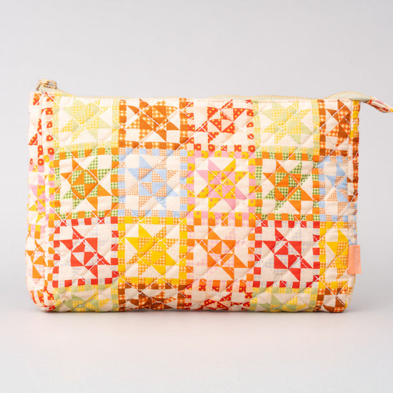 Quilted pouch by bando with geometric star pattern and zipper closure.