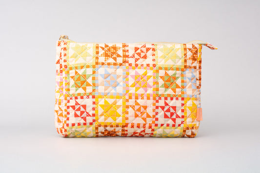 Quilted pouch by bando with geometric star pattern and zipper closure.