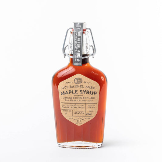 Rye barrel-aged maple syrup in a glass swing top bottle by Finding Home Farms, with a vintage-inspired label.