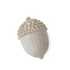 Cream and gold acorn of home decor, featuring textured detailing and decorative spots.