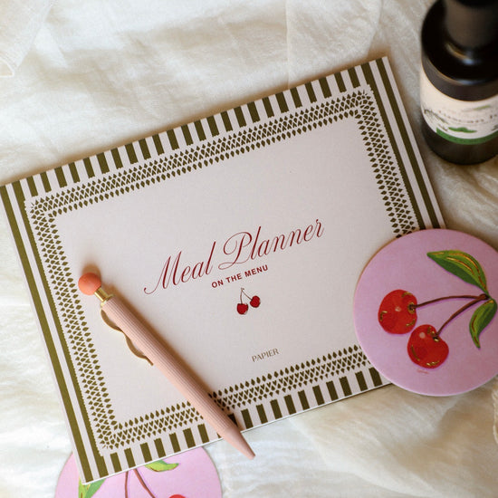 Meal planner with cherry design on a white surface