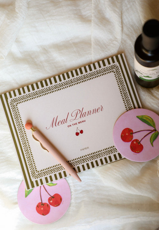 Meal planner with cherry design on a white surface