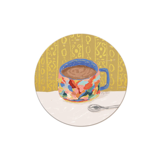 Round decorative coaster with colorful mug illustration from Seedlings, featuring patterned background.