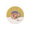 Round decorative coaster with colorful mug illustration from Seedlings, featuring patterned background.