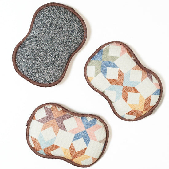 Set of three reusable sponges with star and cube quilt patterns, multicolor design.
