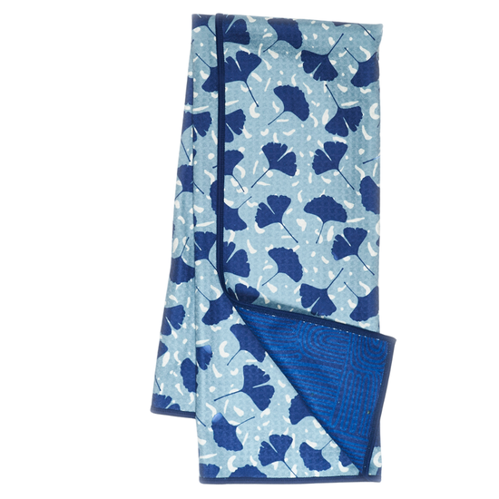 Blue reversible towel with ginko pattern by Zestt Organics, revealing a geometric pattern on its reverse side.
