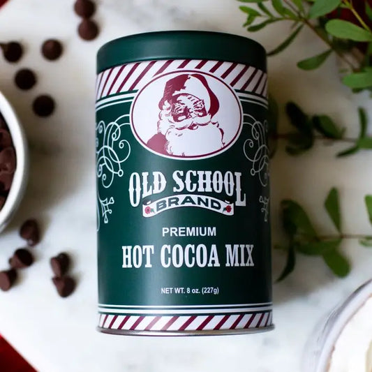 Green Santa Hot Cocoa Mix by Old School Brand, with red and white stripes and Santa Claus decoration.
