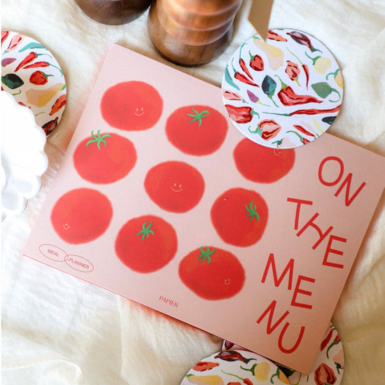 Notebook with tomato stickers and decorative items on a soft surface