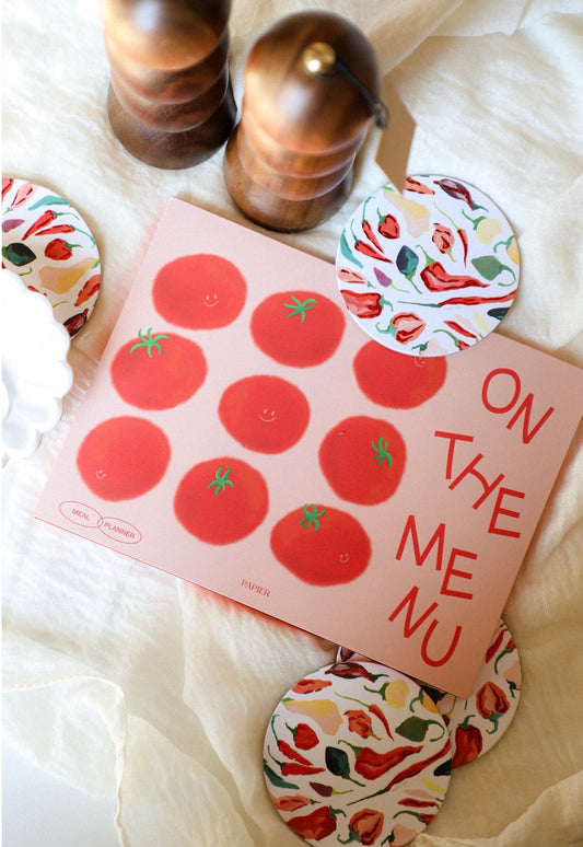 Notebook with tomato stickers and decorative items on a soft surface