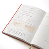 A5 hardcover journal by Papier, displaying an open page with daily intentions, a green ribbon bookmark.