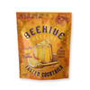 Frozen Beehive Bellini cocktails by Noble Mick's with orange honeycomb pattern and peach slice.