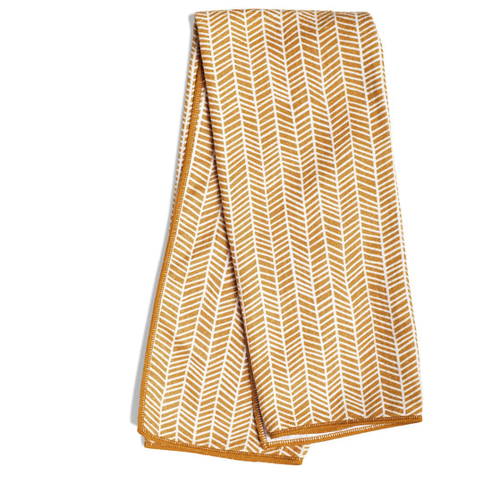 Gold towel with branches pattern from Kitchen & Tabletop, folded with a border.