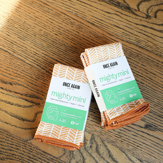 Set of orange and white reusable paper towels by Once Again, displayed on a wooden surface.