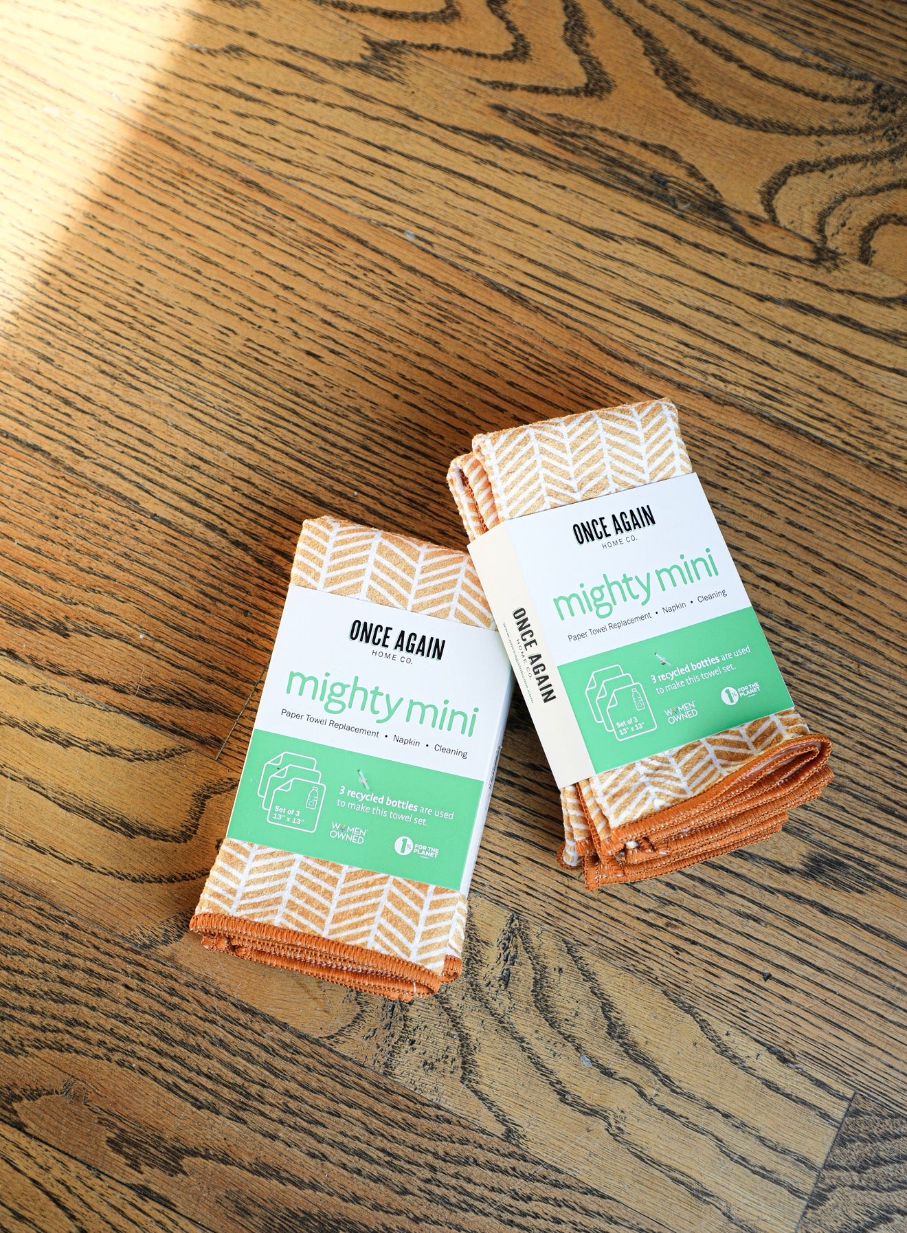 Set of orange and white reusable paper towels by Once Again, displayed on a wooden surface.