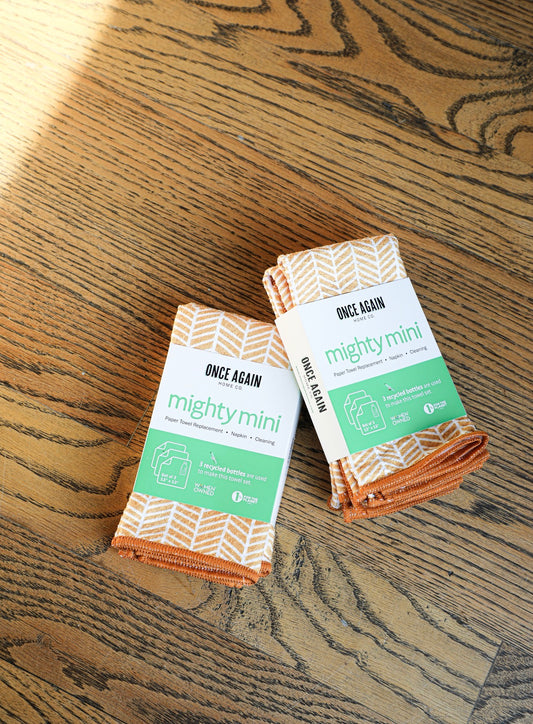 Set of orange and white reusable paper towels by Once Again, displayed on a wooden surface.