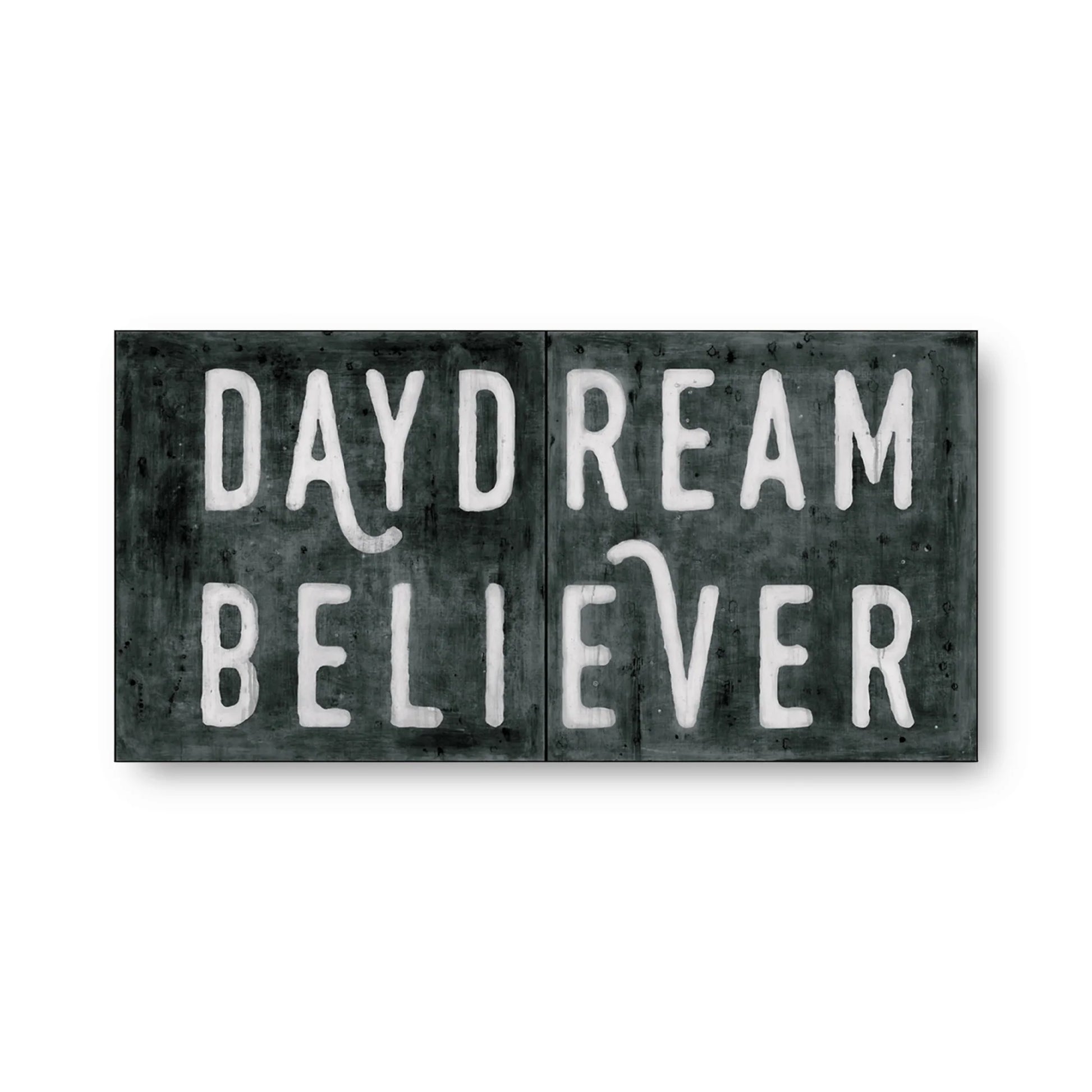 Black and white art tiles with 'Daydream Believer' text, featuring weathered texture.
