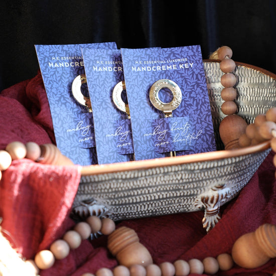 Handcreme key with gold-tone accents by Margot Elena sitting in a textured basket with wooden beads.