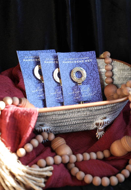 Handcreme key with gold-tone accents by Margot Elena sitting in a textured basket with wooden beads.