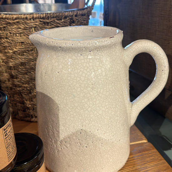 White crackle glazed terracotta pitcher from Kitchen & Tabletop, featuring a round handle and decorative texture.