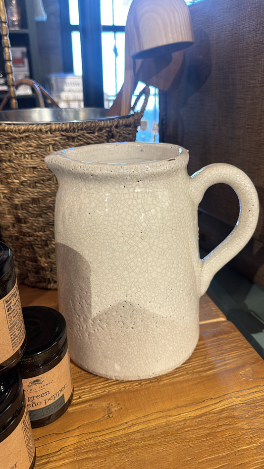 White crackle glazed terracotta pitcher from Kitchen & Tabletop, featuring a round handle and decorative texture.