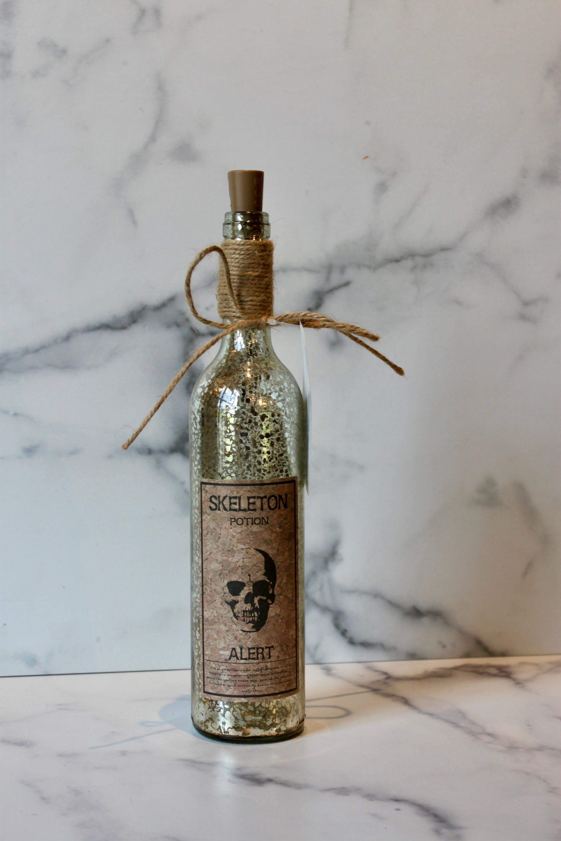 Decorative Halloween potion bottle with cork by Foreside, featuring a distressed silver finish and novelty label.