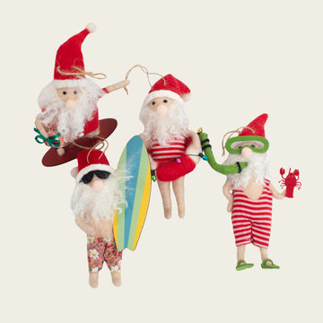 Felt Santa ornaments with surfboards by Cody Foster, depicting beach themed Christmas vacation.
