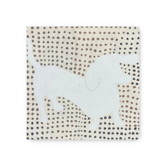Decorative art tile with a white dachshund by an unknown maker, set against an off-white background with brown and black polka dots.